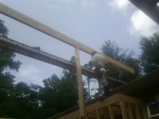 Carpenter setting a ridge beam over a new addition frame — Ice Dam Removal by Roofing Brothers in Pierpont