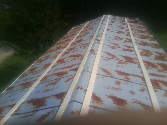 Rusted metal roof panels with new wood purlins before replacement — Storm Damage Roof Repair in Pierpont by Roofing Brothers