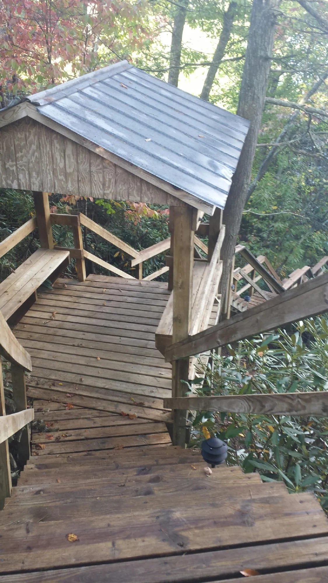 Metal roofed shelter over wooden steps on a wooded walkway — Skylight Repair & Installation work by our crew in Pierpont