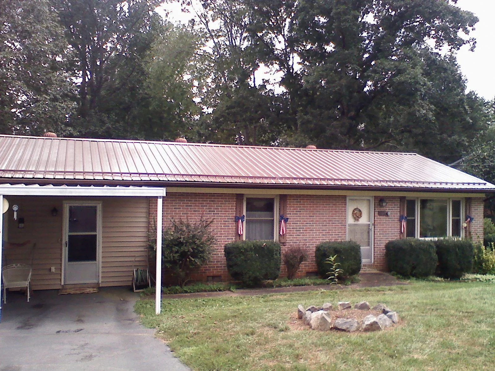 Bronze metal roof and carport on a brick ranch home — Roof Repair work by our crew in Pierpont